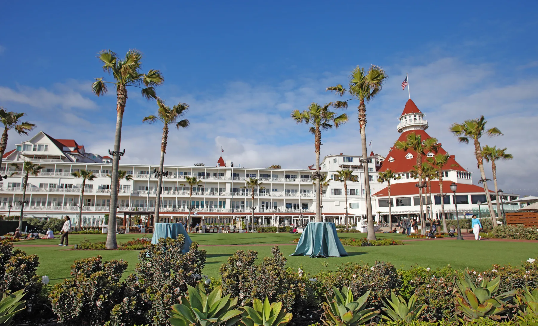 Red-roofed Hotel del Coronado rising beyond a sandy beach