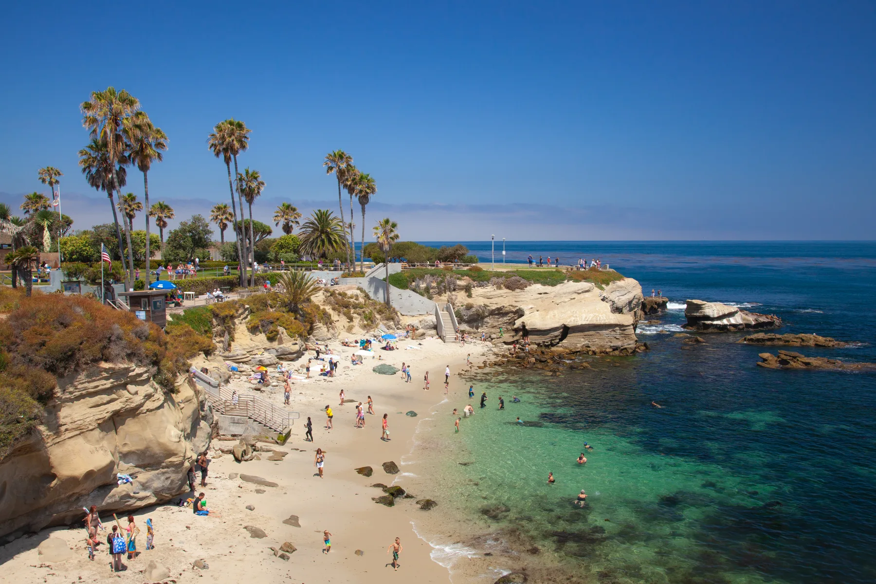 Blue Pacific water, rocks and a sandy edge at La Jolla Cove
